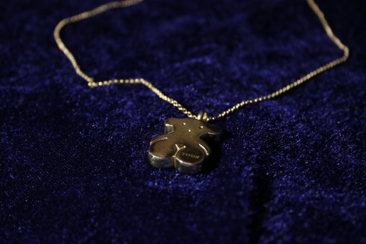 Detalle del dije de oso Tous con el grabado TOUS