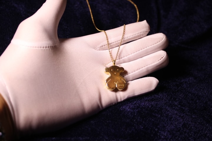 Cadena Tous de oro 18K con dije de oso Sweet Dolls sobre la mano